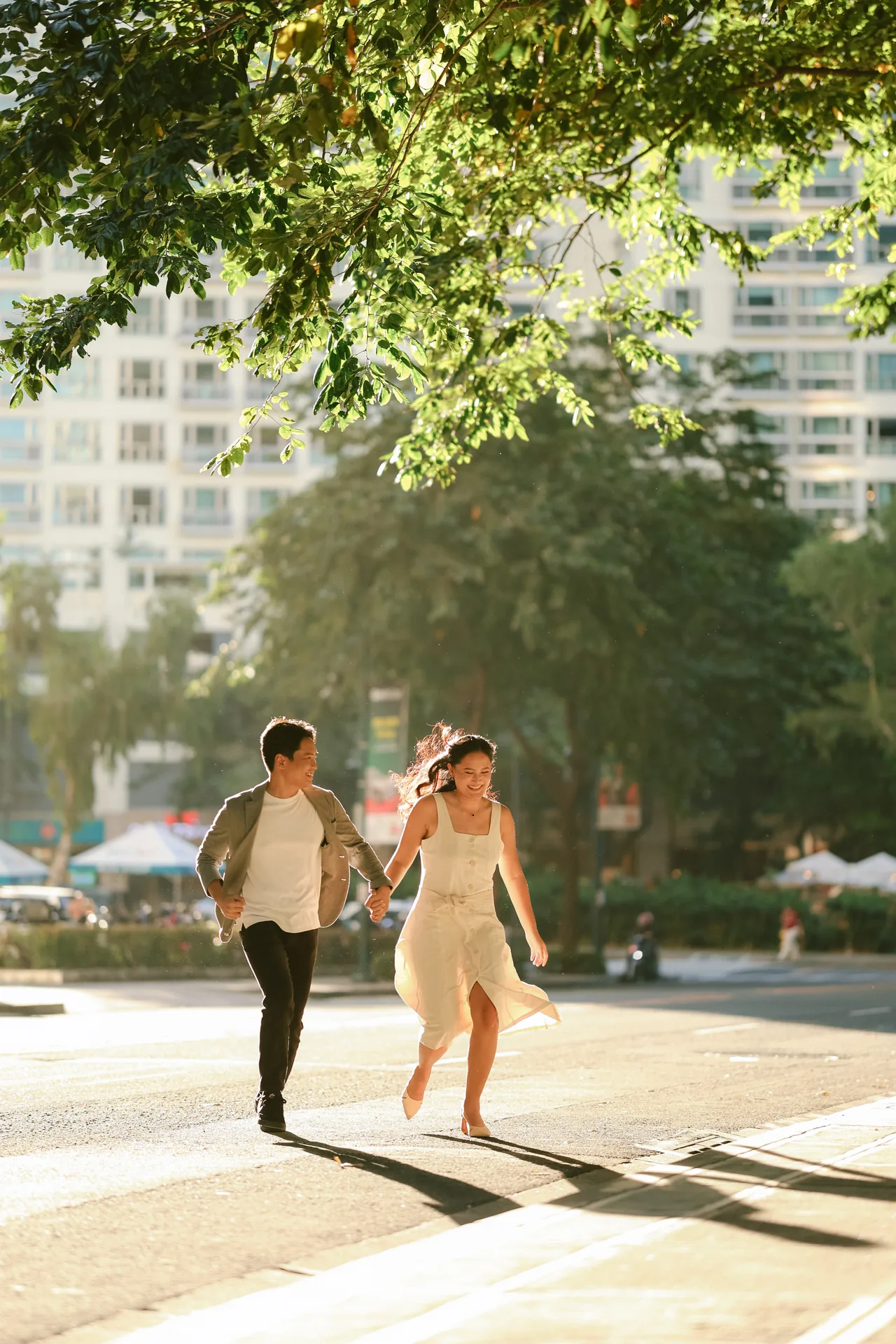 Stephen and Michelle running hand in hand across a sunlit street