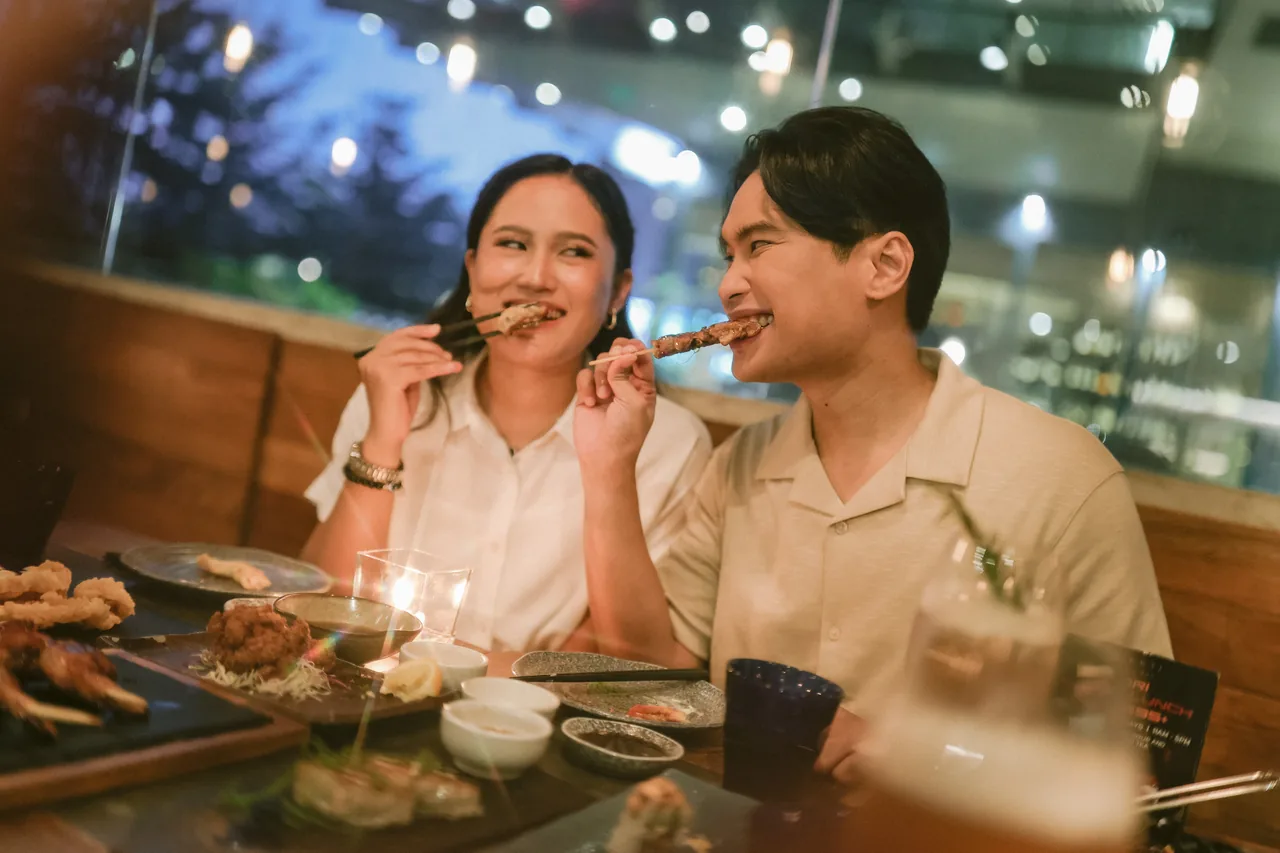 Stephen and Michelle smiling at each other while sharing dinner