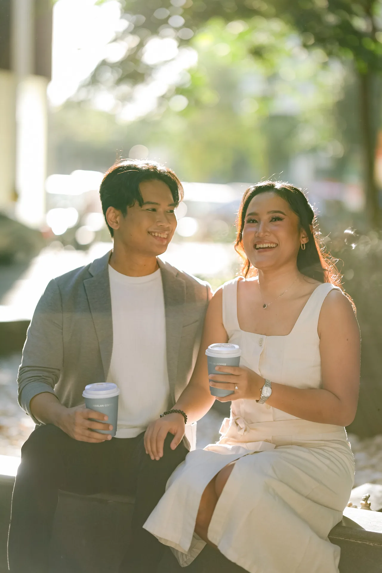 Stephen and Michelle laughing together on a sunlit bench